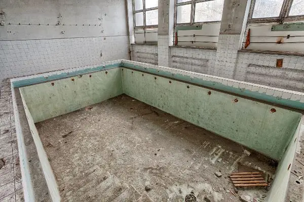 Forgotten, old swimming pool in a ruined building